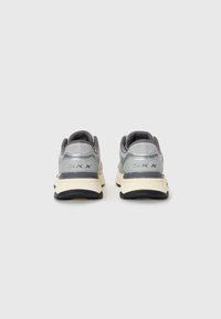 Gray athletic shoes with a mesh upper, padded collar, and reflective accents. Cream midsole and black rubber outsole for traction.