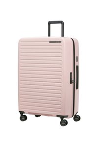 Rosa Hartschalenkoffer mit gerillter Textur, schwarzem Griff und Rollen. Verfügt über einen Reißverschluss und einen seitlichen Griff für einfachen Transport.