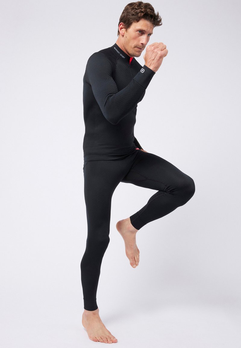 Schwarzes thermisches Baselayer-Set mit strukturiertem Stoff, figurschmeichelndem Design, langen Ärmeln und elastischen Bündchen, ideal für aktive Outdoor-Bekleidung.