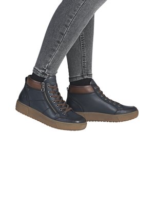 High-top shoes in navy leather with brown leather accents, featuring a side zipper, lace-up front, and textured gum rubber sole.