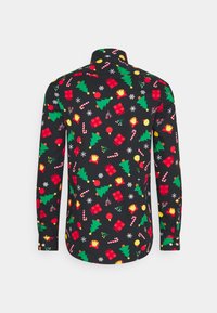 Czarna koszula zapinana na guziki z świątecznym wzorem choinek, prezentów, ozdób, cukierków w kształcie laski i płatków śniegu w kolorach czerwonym, zielonym i żółtym.