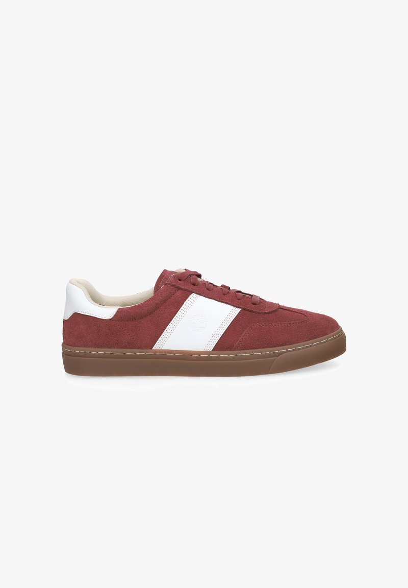 Baskets basses en daim rouille avec une bande latérale blanche et un col matelassé, semelle en caoutchouc marron et fermeture à lacets.