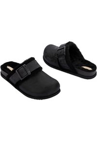 Black clogs with a smooth material, fuzzy inner lining, and an adjustable strap. Rounded toe and textured sole for grip.