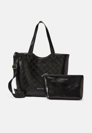 Svart vadderad läder tote-väska med två handtag och axelrem, som har en avtagbar svart påse med dragkedja och logodetalj.