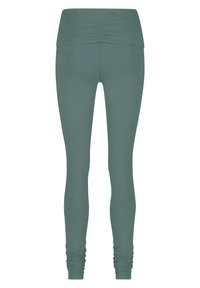 Hochbundige Leggings in einem gedämpften Grünton, aus dehnbarem Stoff mit gerafftem Detail am Bund und schmalen Beinabschlüssen.