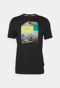 Svart kortärmad T-shirt med en färgglad grafik av Palm Springs, Kalifornien, som har palmer och berg.