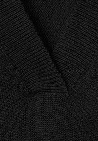 Black knitted sweater with a V-neck, featuring ribbed texture around the neckline and body, creating a cozy appearance.