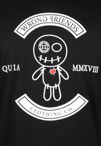 Sort t-shirt med et centralt grafik af en tegneseriefigur med et syet ansigt og et rødt hjerte, omgivet af teksten "WRONG FRIENDS."