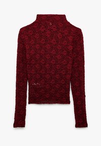 Maglia rossa a maniche lunghe con collo alto, realizzata in un tessuto di pizzo testurizzato con motivo floreale. Design aderente con orlo curvo.