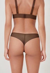 Brązowy zestaw bikini z gładkiego, elastycznego materiału. Biustonosz ma regulowane ramiączka i prosty zamek z tyłu. Majtki mają minimalistyczny krój.