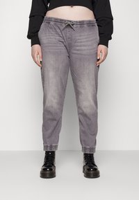 Lysegrå joggebukser laget av myk denim, med elastisk midje med snøring, smalende hem og avslappet passform.