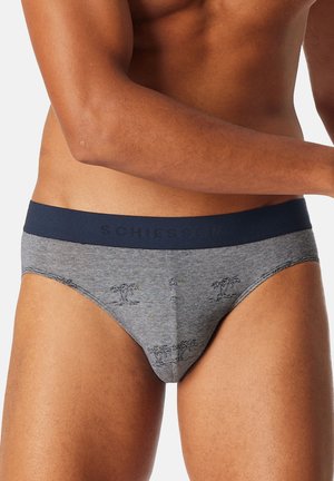 Graue Baumwollslips mit einem marineblauen Bund, der ein Logo trägt. Der Stoff hat ein dezentes Palmenmuster, das für ein strukturiertes Aussehen sorgt.