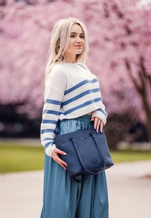 Blue striped sweater with a white base, high-waisted satin teal skirt, and a textured dark blue tote bag.