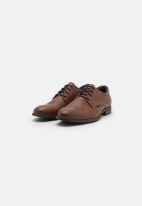 Chaussures habillées en cuir marron avec une texture lisse, un design à lacets, un bout rond et des accents de couleur subtils sur le talon.