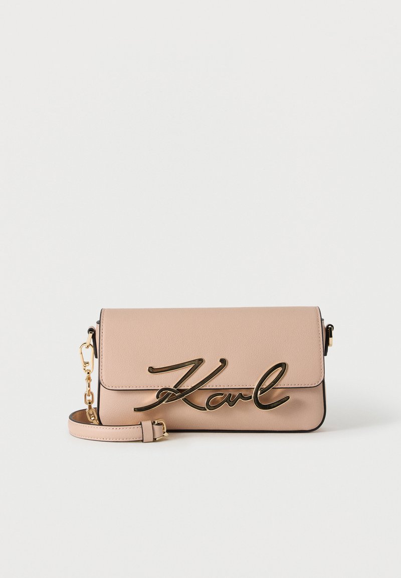 Δερμάτινη τσάντα crossbody σε ροζ απόχρωση με χρυσή αλυσίδα και μεγάλο χρυσό λογότυπο "Karl" στην εμπρόσθια πτέρυγα.