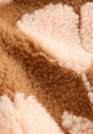 Brown and cream patterned fabric with a fluffy, textured surface, featuring soft wool-like fibers and a layered look.