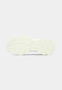 Λευκή σόλα αθλητικού παπουτσιού με υφή από καουτσούκ, που διαθέτει στ ρωματοποιημένο σχέδιο και έντονες αυλακώσεις για πρόσφυση. Ομαλή, στρογγυλεμένη μορφή με ελαφριά καμπύλη.