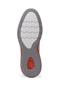Suela de zapato con una superficie de goma gris texturizada que presenta un patrón de panal y un acento rojo cerca del talón.