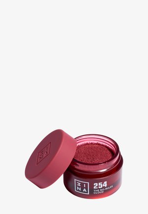 Petit pot ouvert avec maquillage en poudre rouge profond étiqueté 3INA 254 The No-Rules Cloud, avec le couvercle rouge assorti incliné à côté.