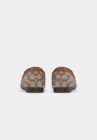 Brown patterned loafers with a textured fabric upper and smooth tan leather accents. Flat black rubber soles and rounded toe design.