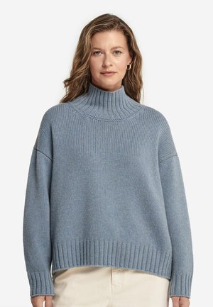 Light blue knitted sweater with a high ribbed collar, dropped shoulders, and ribbed hem. Soft texture and relaxed fit.
