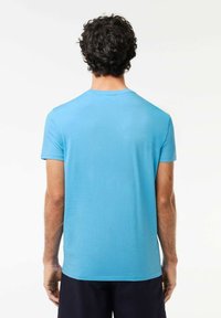 Camiseta de manga corta de color azul claro hecha de una tela suave, con un clásico cuello redondo y un diseño simple y liso sin patrones.