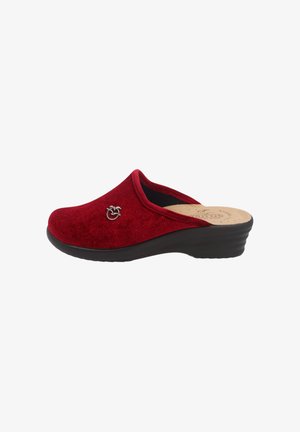 Zoccoli in suede rosso con una bassa suola a cuneo nera, punta tonda e piccolo emblema decorativo metallico sul lato. Superficie texturizzata con glitter.