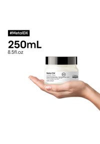 Hvit rund krukke med svart lokk som inneholder 250 ml Metal DX profesjonell maske. Etiketten har svart tekst og logo mot en hvit bakgrunn.