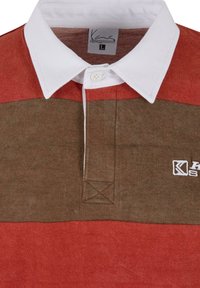 Kortermet polo-skjorte med hvit krage, med horisontale striper i rød og brun. Inkluderer knappestolpe og brodert logo.
