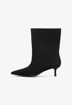 Mustat mokkanahka nilkkurit, joissa on terävä kärki ja matala kitten-korko. Tasainen pinta ja minimalistinen muotoilu ilman huomattavia kuvioita tai yksityiskohtia.