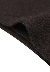 Tissu en laine marron foncé avec une surface texturée et douce, plié à un bord, mettant en valeur les fibres et une apparence légèrement duveteuse.