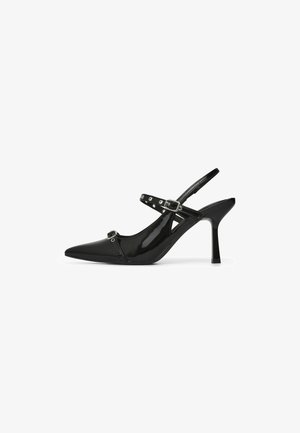 Scarpa décolleté slingback con tacco alto in vernice nera, punta appuntita, due cinturini con fibbia e dettagli in metallo a occhiello su sfondo bianco.