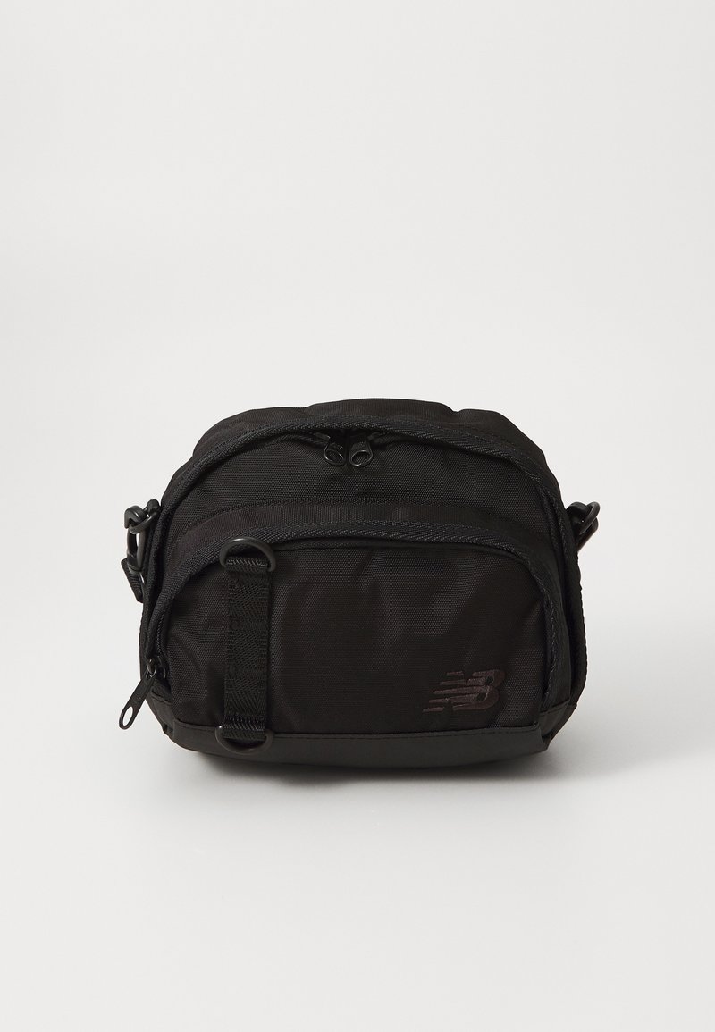 Bolsa tiracolo preta em material de nylon texturizado, com compartimentos duplos com fecho duplo, alça ajustável e logótipo em relevo na frente.