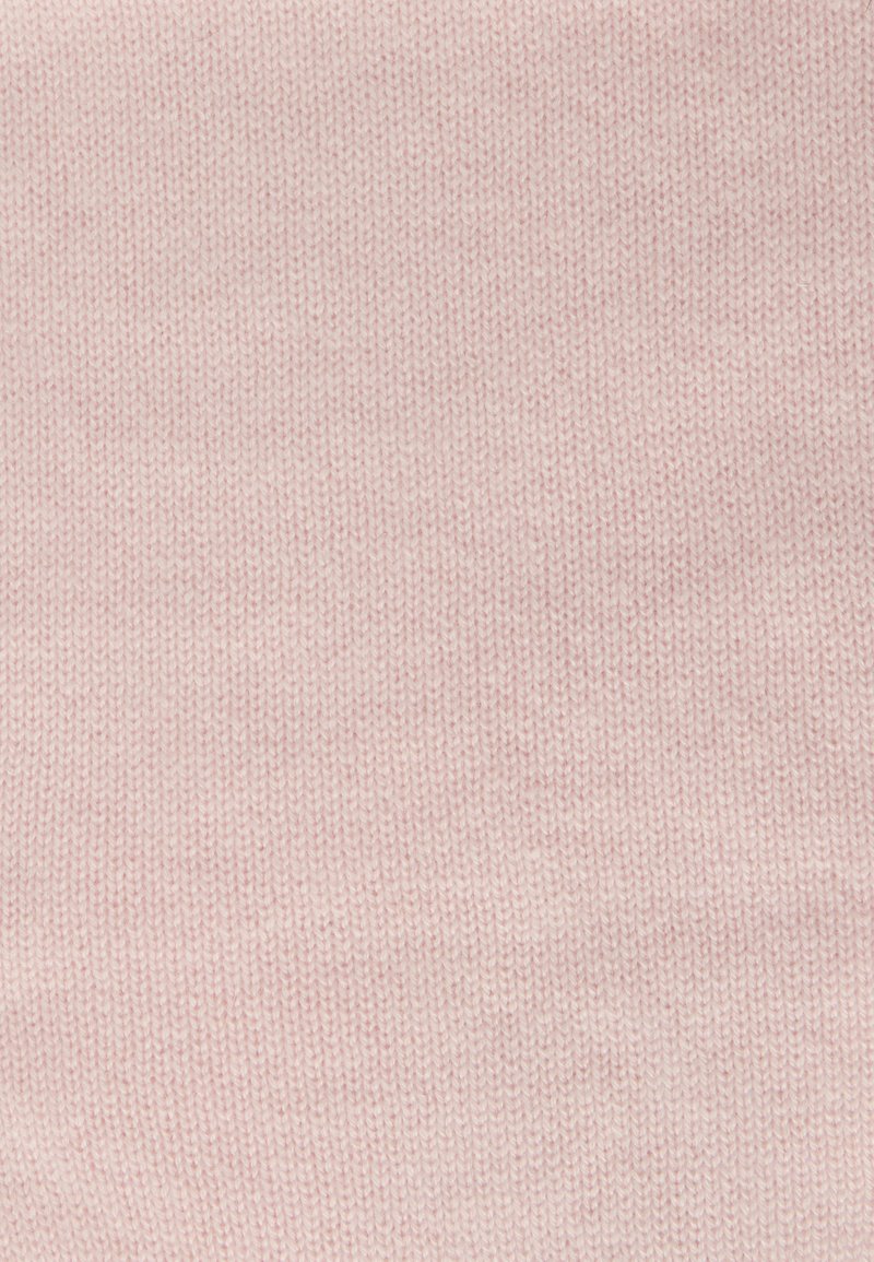 Tissu tricoté rose clair avec une texture fine, présentant un motif uniforme et une apparence douce, adapté aux vêtements ou accessoires.