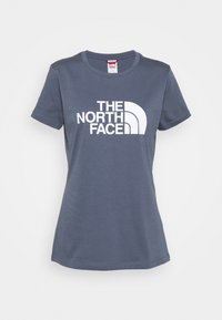 Ciemnoniebieska bawełniana koszulka z okrągłym dekoltem i krótkimi rękawami, z dużym białym logo "THE NORTH FACE" nadrukowanym na przodzie.