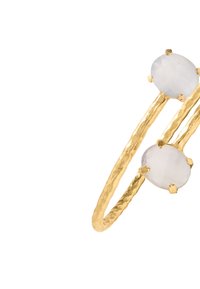Złoty pierścionek z młotkowanym wykończeniem, ozdobiony dwoma owalnymi, jasnymi kamieniami osadzonymi na dwóch paskach i zabezpieczonymi łapkami.