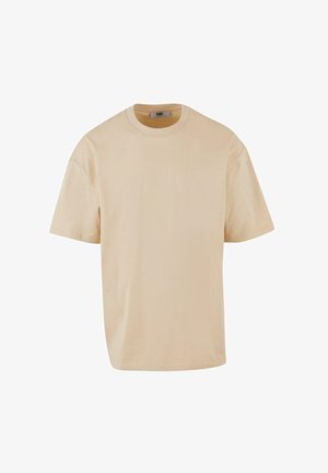 Béžové bavlnené tričko s krátkymi rukávmi, okrúhlym výstrihom, voľným strihom a minimálnym dizajnom. Žiadne viditeľné vzory ani akcenty.