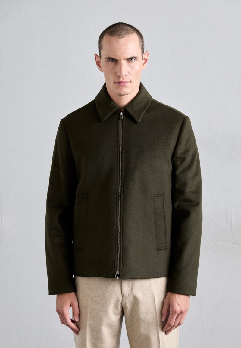 Olive green wool-blend jacket with a notch collar, front zip closure, and two side pockets. Features a structured shape and smooth texture.