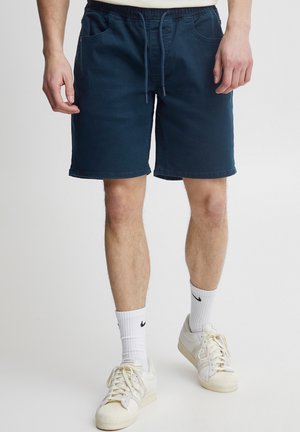 Navy blue shorts made of soft fabric, featuring an elastic waistband, drawstring, and two front pockets. No visible patterns or accents.