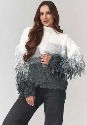 Sweter dziergany w gradientowych odcieniach bieli, szarości i ciemnej szarości; teksturowane, frędzlawe rękawy dodają głębi, miękka tkanina.