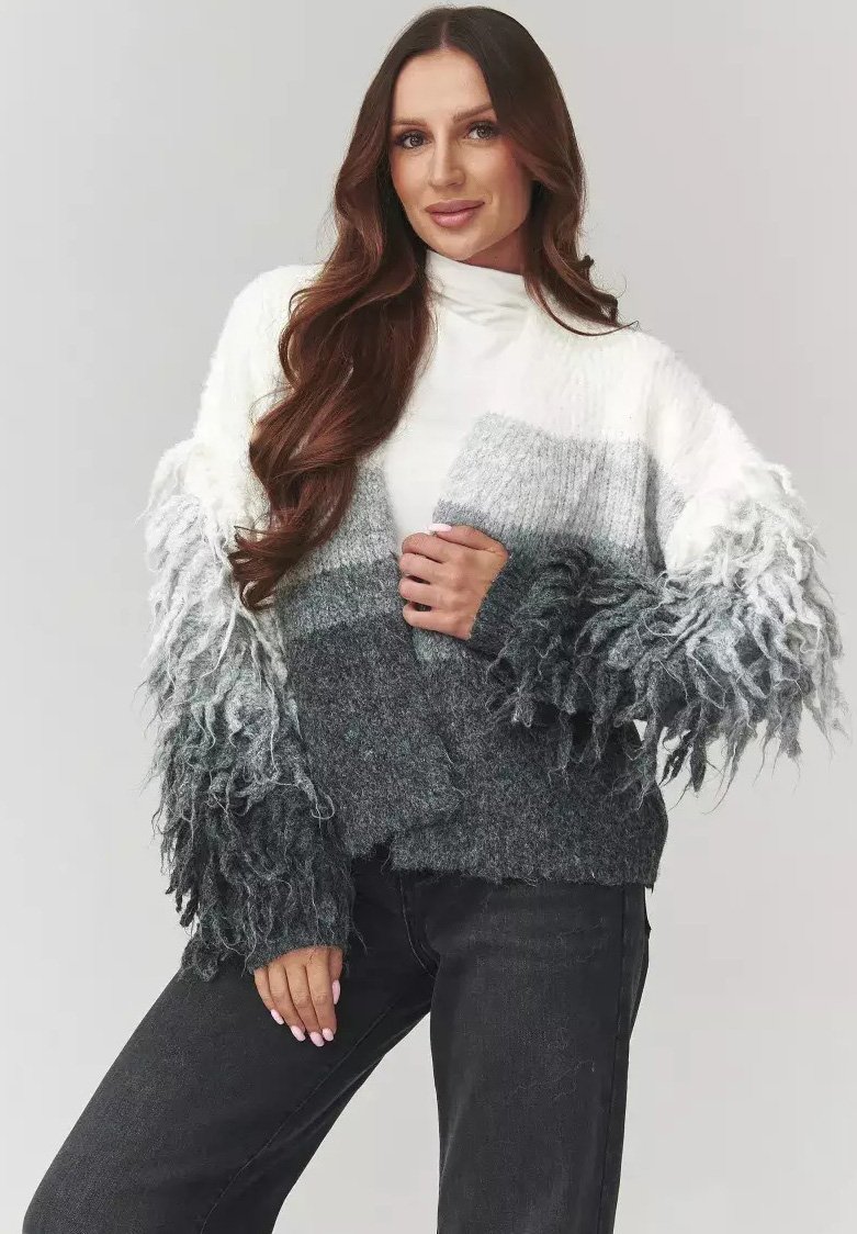 Sweter dziergany w gradientowych odcieniach bieli, szarości i ciemnej szarości; teksturowane, frędzlawe rękawy dodają głębi, miękka tkanina.
