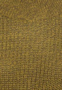 Strickpullover aus einem gemusterten grünen und braunen Garn. Verfügt über ein strukturiertes, geripptes Muster und einen hohen Kragen. Der Stoff wirkt weich und warm.