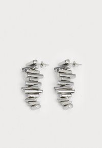 Pendientes de plata compuestos por diversas formas cilíndricas, con un acabado pulido que combina elementos rectos y curvados.