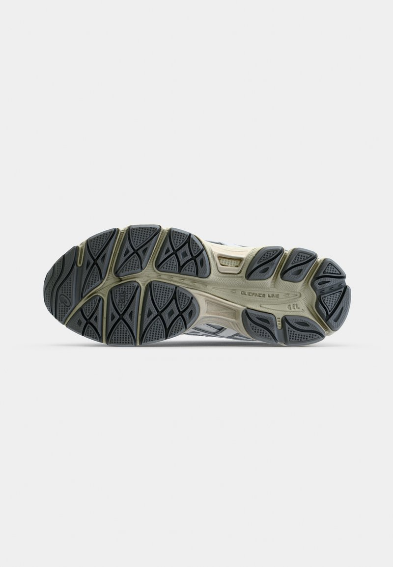 Laufschuhsohle mit einem schwarzen und grauen Gummidesign, texturiert für Grip, mit ausgeprägten Mustern und Rillen für Traktion.