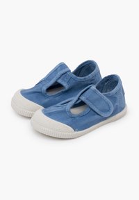 Scarpe di tela blu con suola bianca in gomma, caratterizzate da un design a ritaglio e una tracolla in velcro per una facile chiusura.