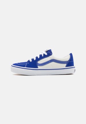Niebieskie i białe zamszowe sneakersy o niskim profilu, z białymi sznurówkami, kontrastowym przeszyciem i gumowymi podeszwami. Podkreślone logo marki.
