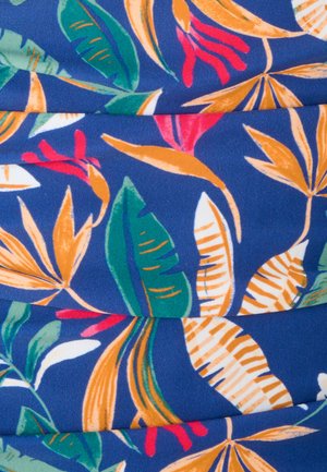 Blauwe stof met tropisch bloemenpatroon met oranje, groene, witte bladeren en rode bloemaccenten, met plooien en textuur zichtbaar.