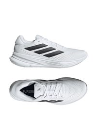 Baskets blanches de sport avec une tige texturée, des rayures noires sur le côté, et une semelle rembourrée pour le confort. Présente un design à lacets.