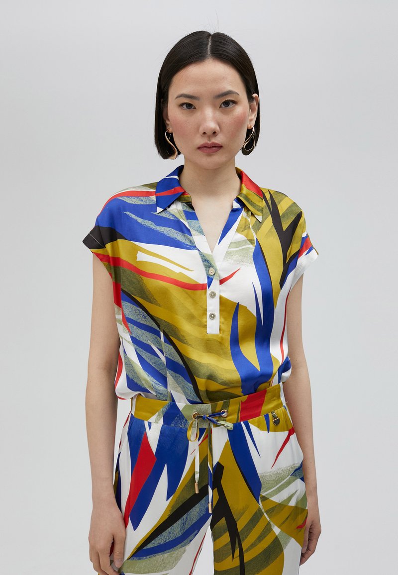 Mnohobarevná blúzka s krátkym rukávom z hodvábu, s golierom, zapínaním na gombíky a abstraktnými vzormi modrej, červenej a žltej farby.