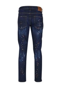 Džínové kalhoty s tmavým odstínem, úzkého střihu, s mnohobarevnými skvrnami od barvy a dvěma zadními kapsami. Hnědý umělý kožený štítek na pasu.